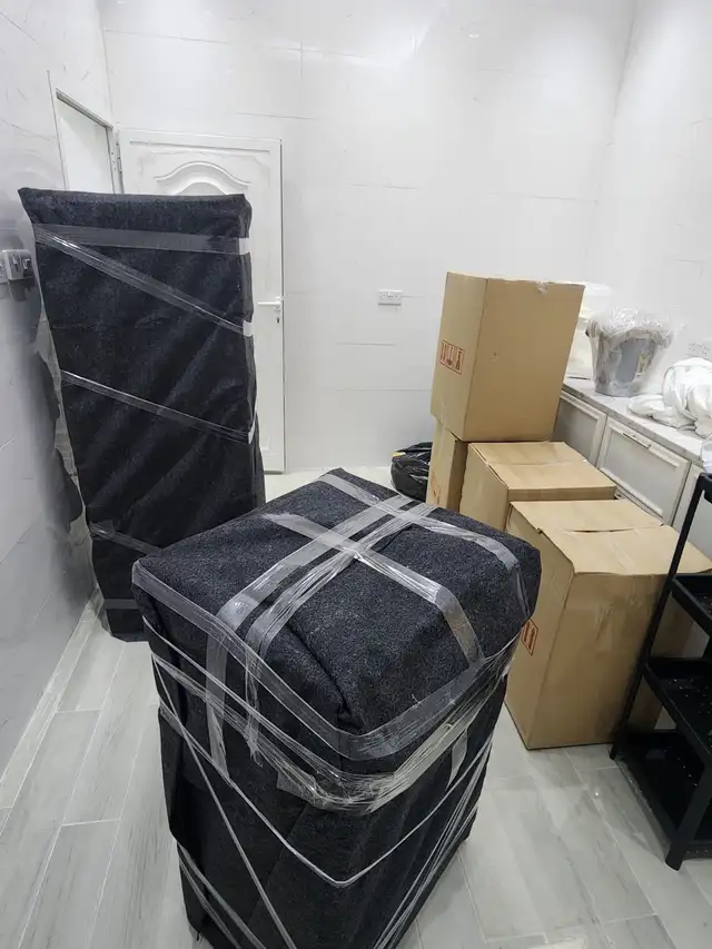 Villa movers wrapping and protecting large furniture before transport
